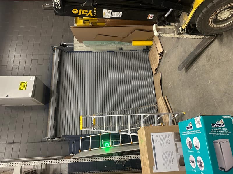 Closed gray commercial rolling steel door at industrial loading bay